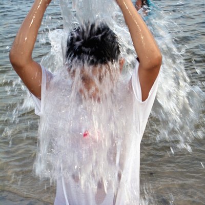 Child pouring a bucket of water over his head