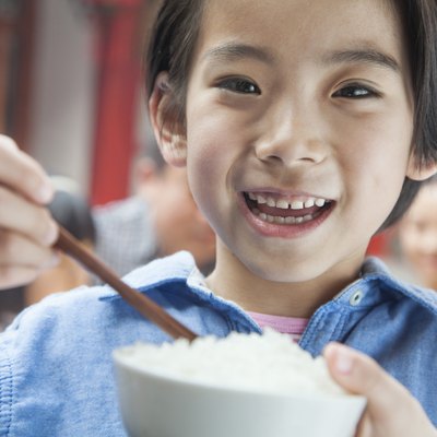 Portrait of little girl eating rice