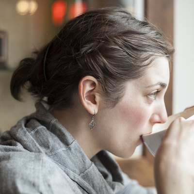 Beautiful Young Woman Drinking Her Morning Cup of Coffee