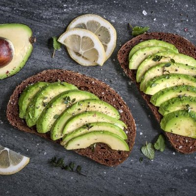 Avocado sandwich on dark rye bread made with fresh sliced avocados.