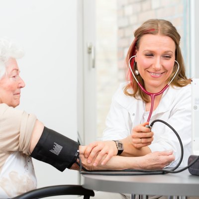 doctor measuring blood pressure of senior patient