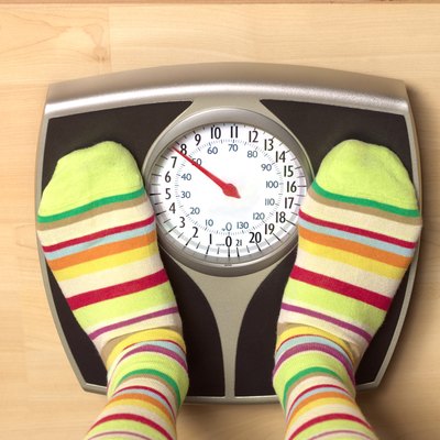 Dieting woman on bathroom scales