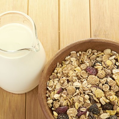 Plate with raw oatmeal on wooden table.