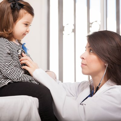 Pediatrician examining little girl