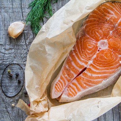 Salmon steak with pepper, dill, lemon, garlic on baking paper