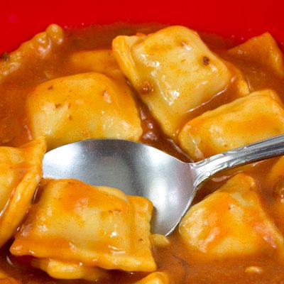 Ravioli in a red bowl with a spoon