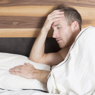 Bright shoot of upset man lies in the bed