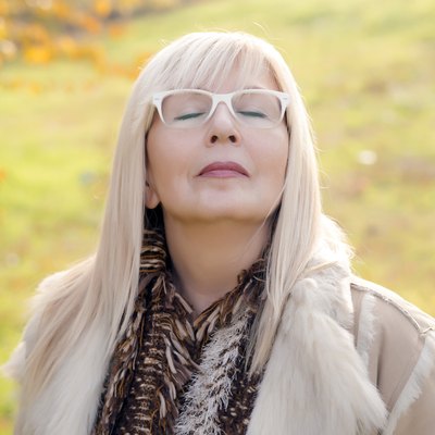 Portrait of a relaxed autumn mature woman breathing deep