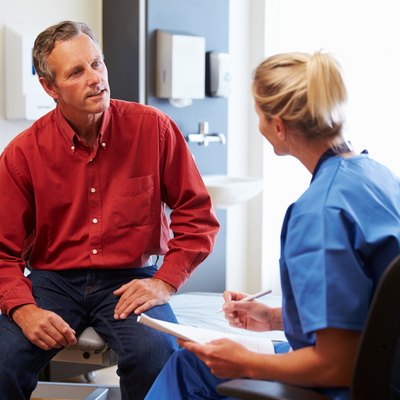 Patient And Female Doctor Have Consultation In Hospital Room