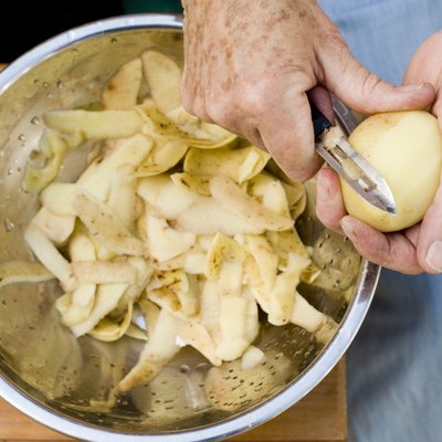 Person's hands peeling potatoes
