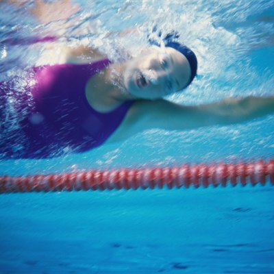 Low angle view of a young woman swimming underwater in a swimming pool