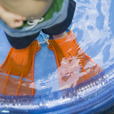 Boy wearing flippers in kiddie pool