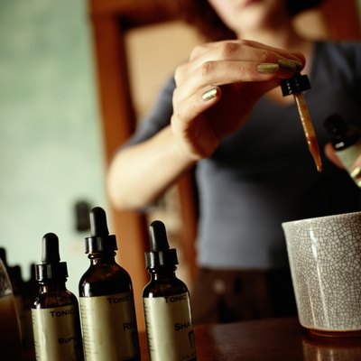 Woman Dispensing an Eyedropper of Herbal Tonic