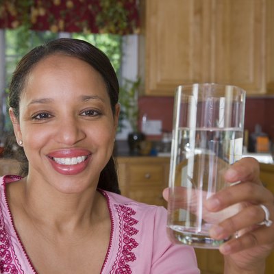 Hispanic woman holding a glass of water and smiling