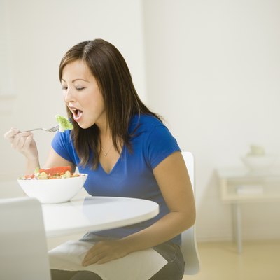 Asian woman eating salad