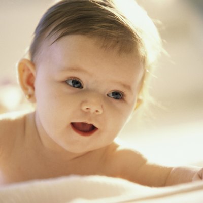 Close-up of a baby girl lying on a bed