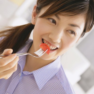 Young Woman Eating Tomato