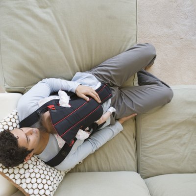 Hispanic father sleeping on sofa with baby