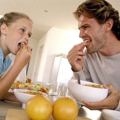 Father and daughter eating cereal