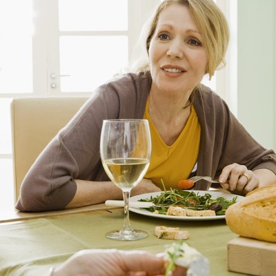 Women eating meal with wine