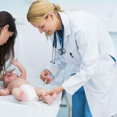 Mother and female doctor doing an injection on a crying newborn