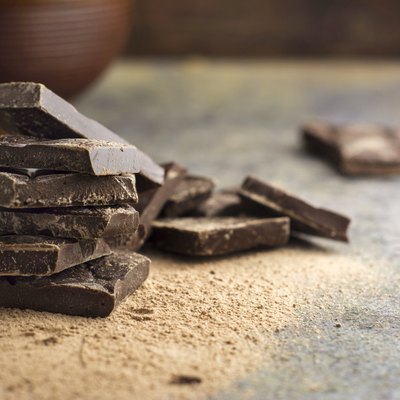 pieces of dark chocolate stacked on grunge background