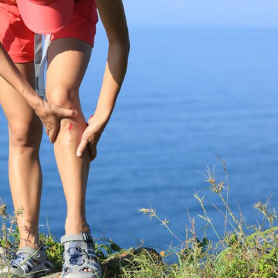 young sporty woman hold her sports injured leg