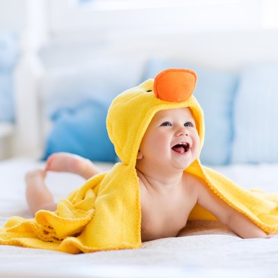 Funny cute baby after bath in yellow duck towel