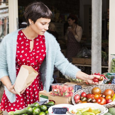 Woman selecting tomatoes at local farm shop.