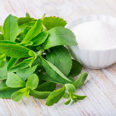 Fresh stevia leaves and bowl with sugar