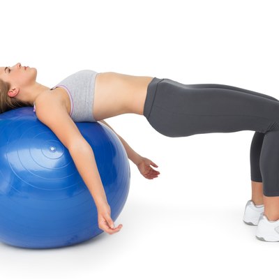 Fit young woman exercising with fitness ball