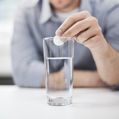 Man dropping antacid into a glass of water
