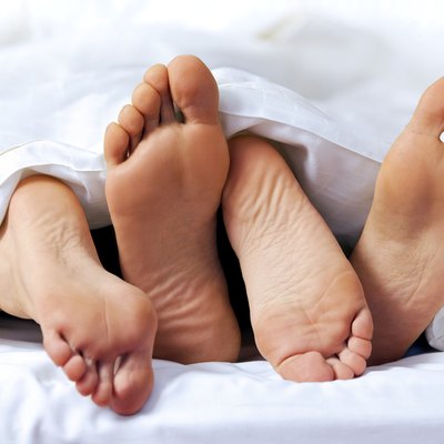 Close-up of the feet of a couple on the bed