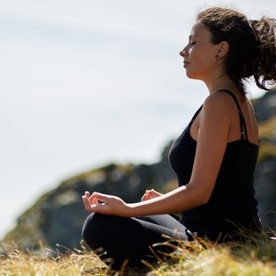 Woman practicing yoga on mountain