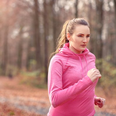Pretty fit young woman jogging in woodland