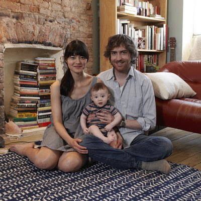 Parents with baby boy (6-11 months) sitting on carpet, smiling, portrait