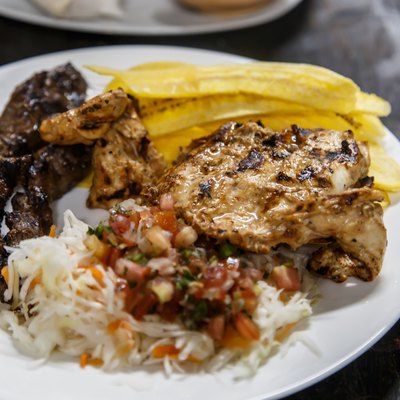 traditional nicaraguan cuisine, roast meat, salad and fried banana.