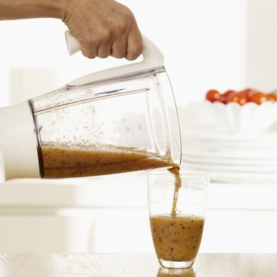 Woman pouring smoothie into glass, close up