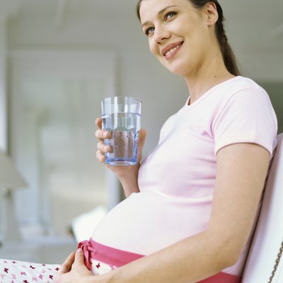low angle view of a pregnant woman holding a glass of water