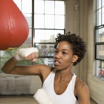Woman exercising with punching bag in gym