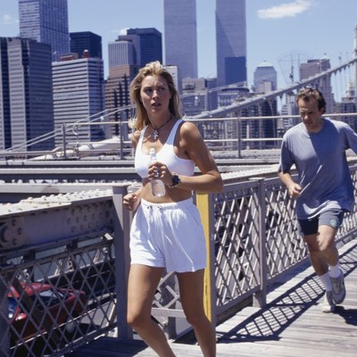 USA, New York City, woman and man jogging on Brooklyn Bridge