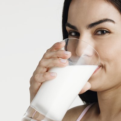 Young woman drinking milk, smiling, portrait, close-up