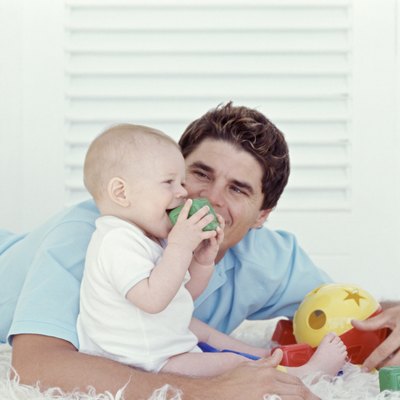 Father playing with baby (6-12 months), indoors