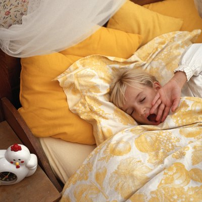 Girl (6-7) yawning in bed, eyes closed, elevated view