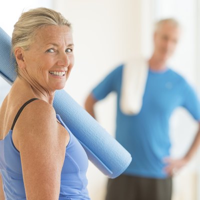 Smiling Woman With Exercise Mat At Home