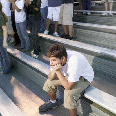 Teenage boy alone near crowd