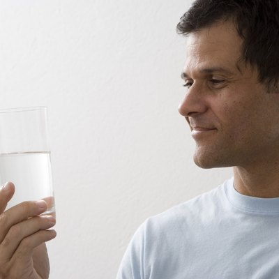 Mature man holding glass of water and smiling
