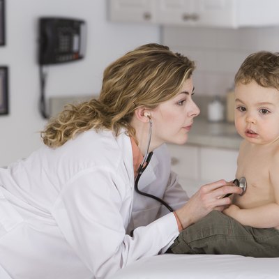 Doctor examining boy with stethoscope