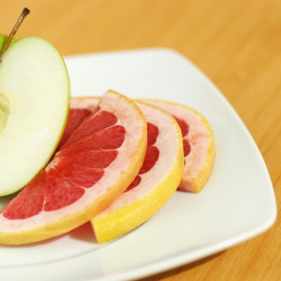 Close-up of an apple pie and slice of grapefruit in a plate