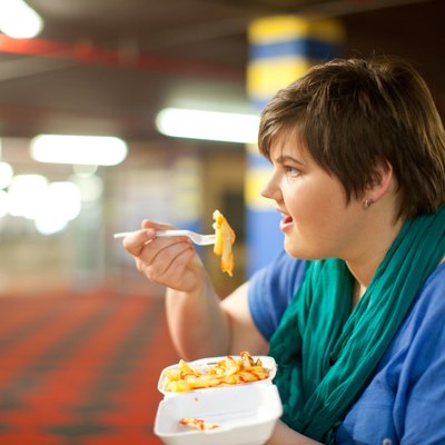 Young woman eating takeaway fries